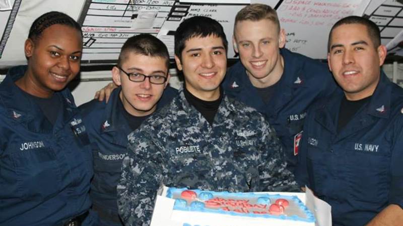 Sailors smile in front of an OBC surprise cake in Japan.