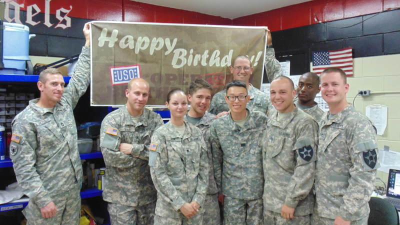 Soldiers smile in front of the birthday sign at Camp Humphreys, South Korea.