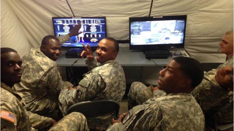 Soldiers deployed to Camp Buchanan, Liberia, play on gaming systems donated by USO at the Morale, Welfare and Recreation tent.