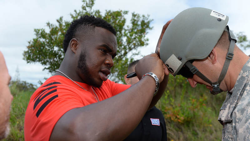 Atlanta Falcons defensive tackle Grady Jarrett signs a soldier's helmet during a weeklong USO/NFL tour to Guam and Hawaii.