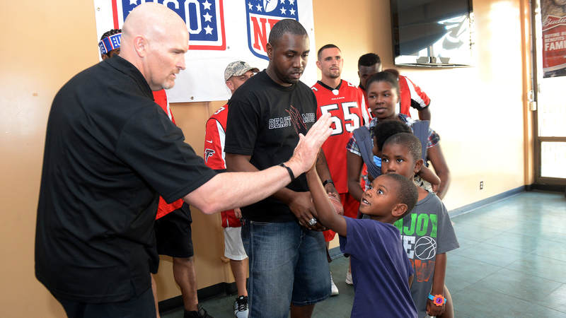 Atlanta Falcons head coach high-fives one of his littlest fans during a weeklong USO/NFL tour to Guam and Hawaii.