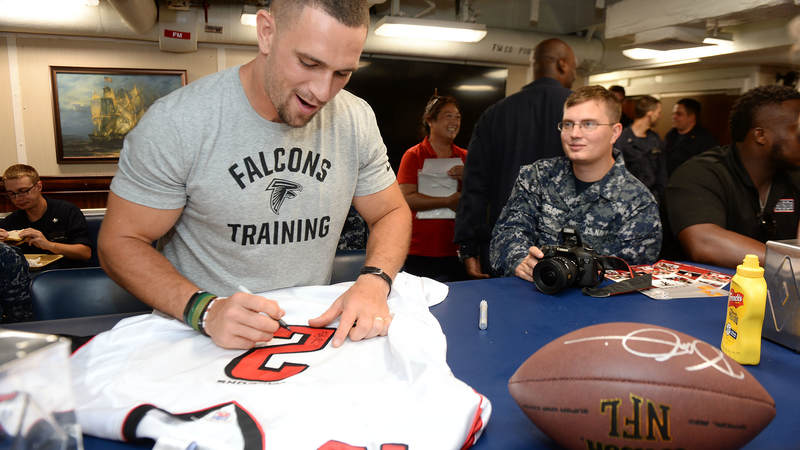 Atlanta Falcons linebacker Paul Worrilow, left, signs a jersey for a sailor during a weeklong USO/NFL tour to Guam and Hawaii.