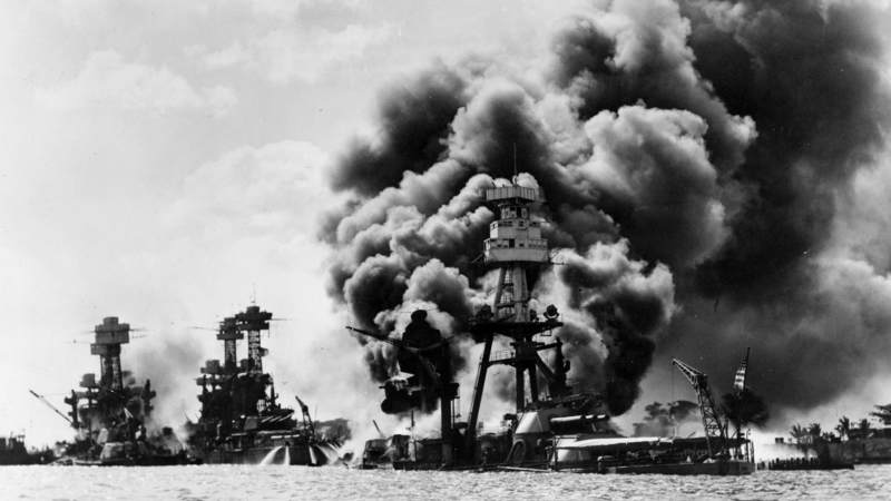 The USS Arizona burns and sinks following the Japanese sneak attack on Pearl Harbor, Hawaii, Dec. 7, 1941. In the background are the battleships USS West Virginia, left, and USS Tennessee, both damaged during the attack.