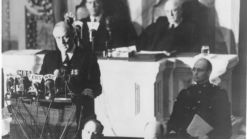 President Franklin Delano Roosevelt delivers his "Day of Infamy" speech to Congress on December 8, 1941. Behind him are Vice President Henry Wallace, left, and Speaker of the House Sam Rayburn. To the right, in uniform in front of Rayburn, is Roosevelt's son James, who escorted his father to the Capitol.