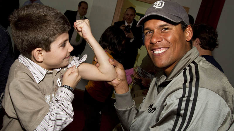 NFL veteran Donnie Edwards makes a new friend while visiting an orphanage in Izmir, Turkey, March 25, 2010. Edwards is joined by New Orleans Saints players Drew Brees and Billy Miller.