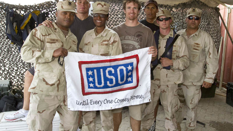 (L to R) NFL’s Billy Miller, Drew Brees and Donnie Edwards pose for photos with members of Maritime Expeditionary Security Squadron Four stationed in Dubaii on March 27, 2010. This is the trio’s third USO tour.