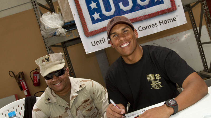 Former Kansas City Chiefs linebacker Donnie Edwards signs an autograph for U.S. Navy Gunners Mate Second Class Marvin Leon Ford, Jr. while in Dubaii on March 27, 2010.
