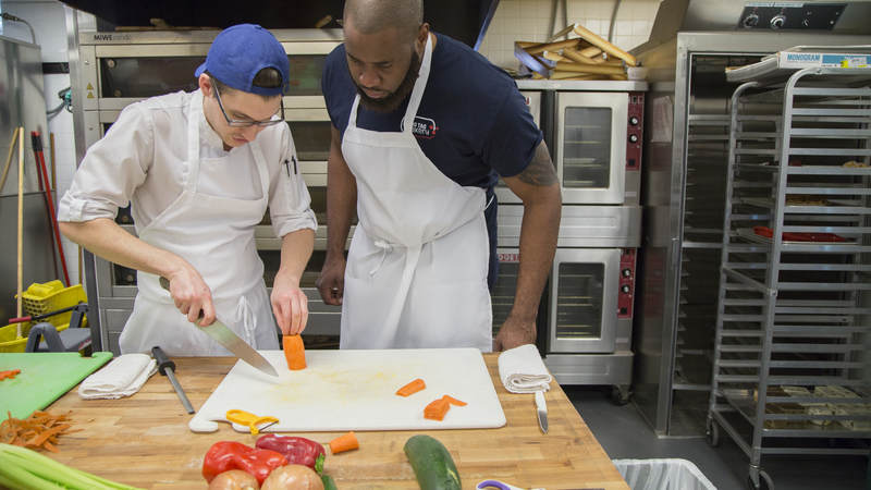 A Dog Tag Bakery fellow Nnana Obioha learns knife skills.