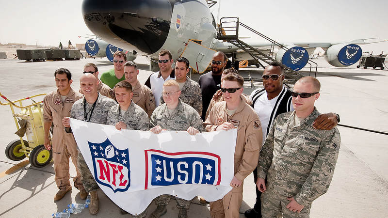 NFL players Jason Witten-Dallas Cowbys (L), Joe Thomas-Cleveland Browns (L-middle), Mario Williams-Houston Texans (R-middle) and Vernon Davis-San Francisco 49ers (R) pose for a group shot with the ground and air crew of a RC 135/JSTARS aircraft behind them, March 3, 2010. The four NFL All Stars are taking part in their first USO tour, traveling to nine bases in eight days to boost morale, sign autographs and extend their thanks to America's troops.