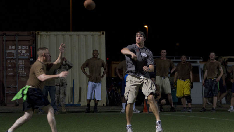 New Orleans Saints quarterback Drew Brees gets rushed by service members as he plays an exhibition football game with troops at Camp Lemonnier in Djibouti on March 29, 2010. Brees is in the region as part of a nine-day USO tour designed to boost morale and bring troops a touch of home.