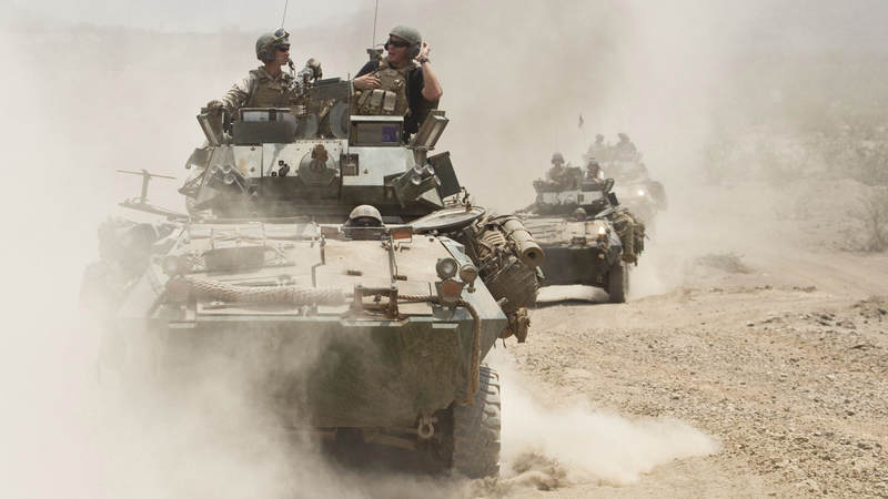 New Orleans Saints tight end Billy Miller is seen through the smoke, dust and sand atop an LAV (Light Armored Vehicle) belonging to the 24th Marine Expeditionary Unit at Camp Lemonnier in Djibouti on March 29, 2010. Miller was joined by teammate and Super Bowl MVP Drew Brees and NFL player Donnie Edwards, as part of their third USO tour together.