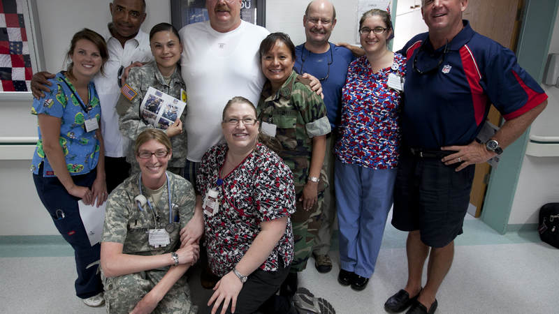Cincinnati Bengals head coach Marvin Lewis (back row L), Philadelphia Eagles head coach Andy Reid (back row 2nd l) , Minnesota Vikings head coach Brad Childress (3rd r) and Carolina Panthers head coach John Fox ® pose for a photo with medical staff during a USO tour stop at Landsthul Regional Medical Center in Germany on June 29, 2010.