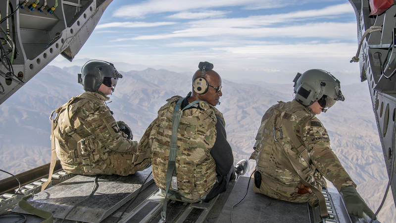 Former NBA star Ray Allen, center, sits on the back of an Army helicopter and looks out over Afghanistan during the USO Chairman’s Holiday Tour in December 2016.