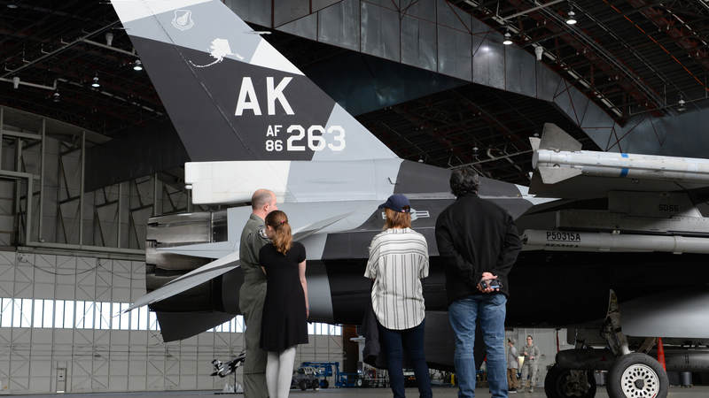 Air Force Col. Todd Robbins, the 354th Fighter Wing vice commander, speaks with Cassadee Pope and her tour manager about the F-16 Fighting Falcon aircraft April 8 at Eielson Air Force Base, Alaska.
