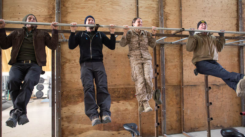 From left, Adam Rodriguez, Nick Zano and Channing Tatum (far right) have a pull-up contest with a service member during a USO tour stop in Afghanistan