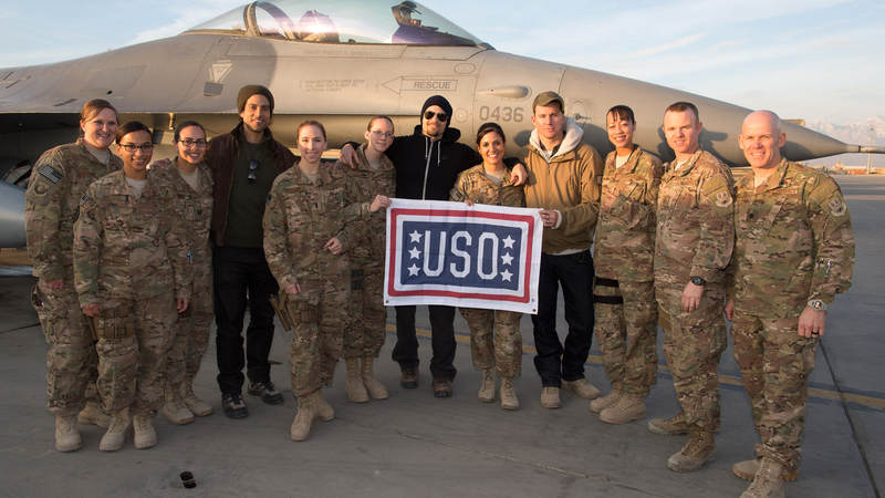 Actors Adam Rodriguez, Nick Zano and Channing Tatum pose with service members in front of an F-16 in Afghanistan.