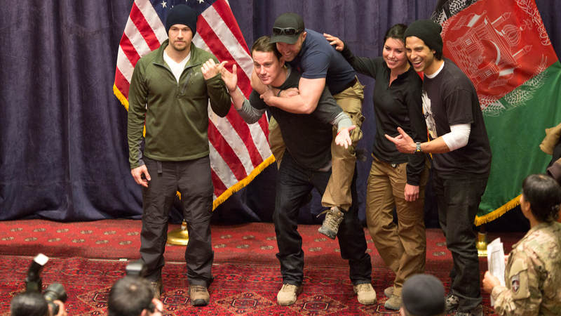 Channing Tatum gives a service member a piggy-back ride while posing for a photo during a USO tour.