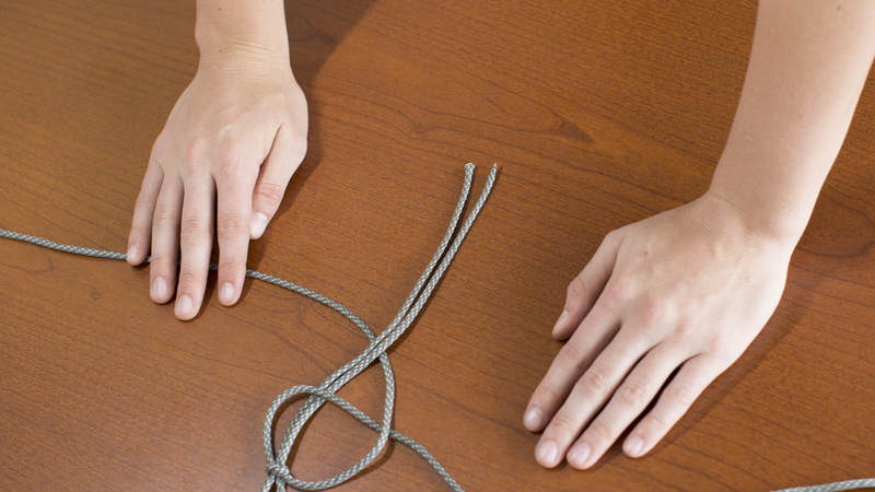 6. Take the left long strand of cord and cross it over the other long strand of cord and under the middle two short strands of cord.