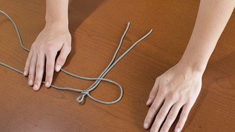 9. Now, repeat on this process on opposite side. Take the left long strand of cord and cross it over to the right.