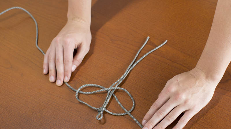 10. Take the right long strand of cord and cross it over the other long strand of cord and under the middle two short strands of cord. Loop this same strand through the loop you created on the left. Pull tight!