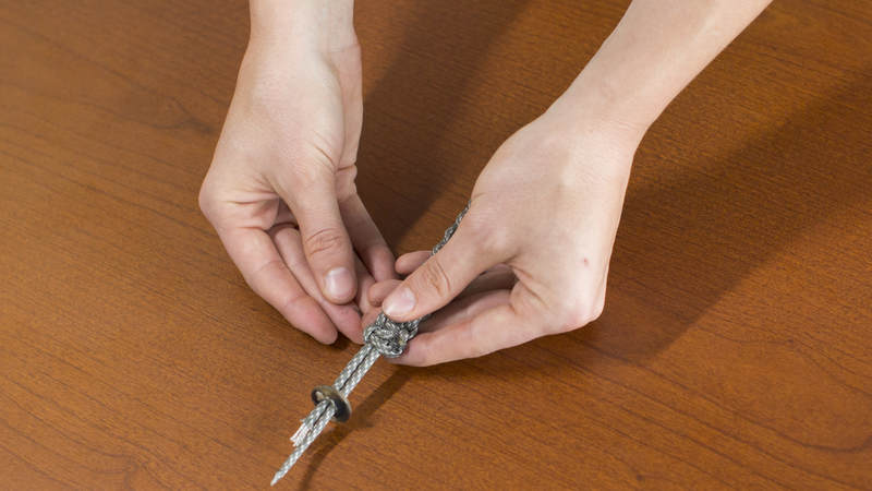 14. Thread both cords of the bracelet through the button hole.