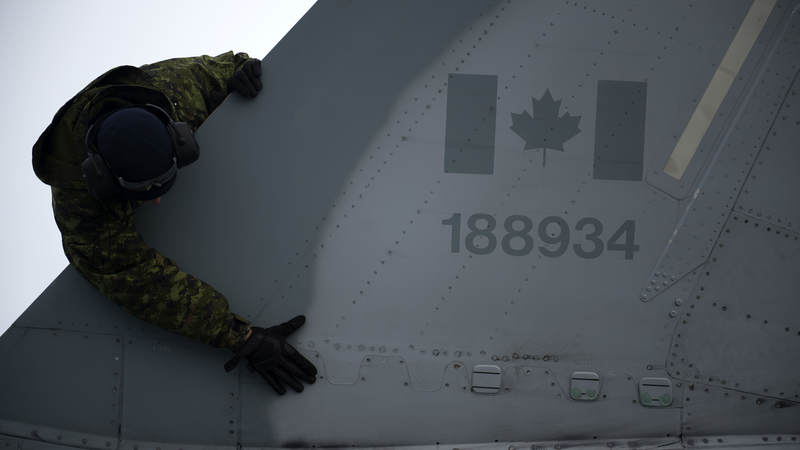 A member of the Royal Canadian Air Force completes a post flight check during an exercise on Thule Air Base, Greenland.