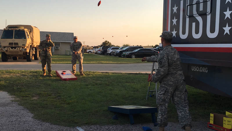 Service members play games outside the USO Mobile unit.