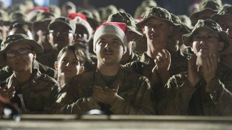 Soldiers from the 3rd and 4th Brigade, 10th Mountain Division, watch the USO Holiday Tour at Q-West, Iraq, on Christmas Day.