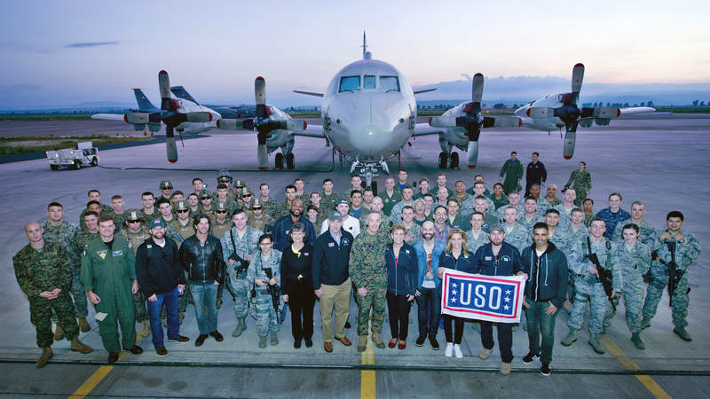Banks and other tour participants pose in front of a P-3 Orion aircraft.