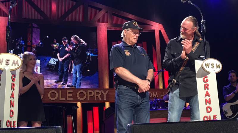 Trace Adkins cheers for USO volunteer Roland Forand as he's honored during a 2016 celebration at the Grand Ole Opry.