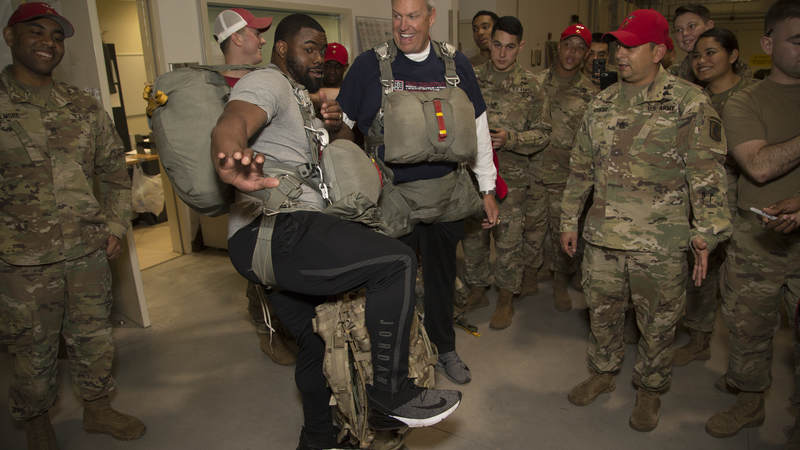 New Orleans Saints running back Mark Ingram, a Heisman Trophy winner, strikes the famous pose while former NFL head coach Rex Ryan looks on.