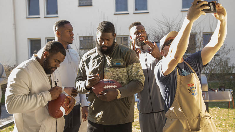 From left to right, NFL players Mark Ingram, Carlos Dunlap, Mario Addison and Latavius Murray sign autographs and take photos during the 2018 USO-NFL tour of military bases in Italy and Germany.