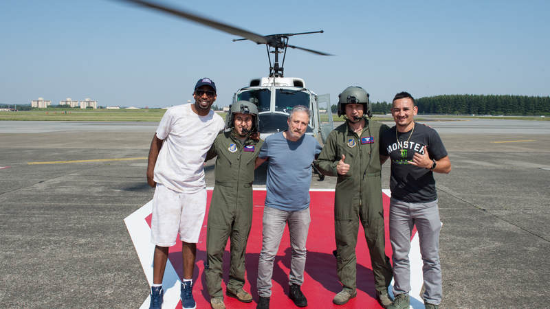 NBA legend Richard "Rip" Hamilton, comedian Jon Stewart and UFC fighter Max "Blessed" Holloway pose for a photo with a UH-1 Huey helicopter aircrew after a helicopter tour of Tokyo from Yokota Air Base, Japan. Army photo by Sgt. James McCann