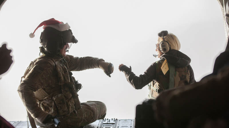 Pickler fist bumps a service member while taking a flight over Afghanistan to another USO tour stop at Forward Operating Base Walton.