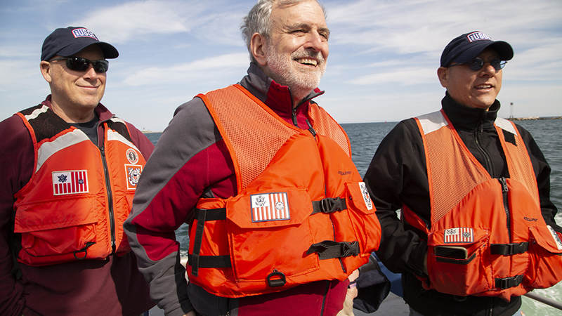 National Cartoonists Society artists Jeff Bacon, left, Sam Viviano, center, and Michael Ramirez, right, enjoy a cruise around Point Judith with the United States Coast Guard Friday during a USO tour there. USO Photo by Joseph Andrew Lee