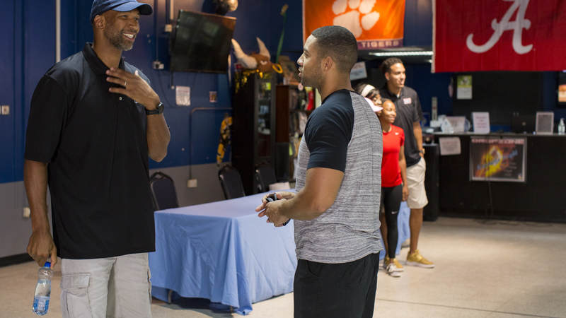 NBA coach Monty Williams smiles with a service member at Ali Al Salem Air Base, Kuwait.
