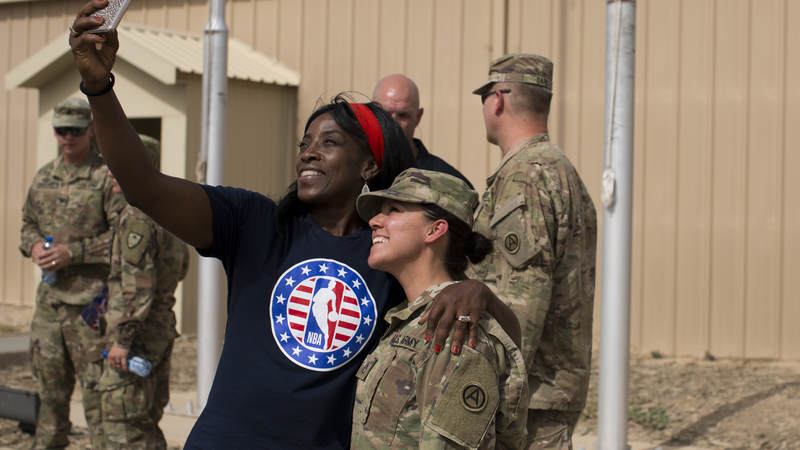 Ruthie Bolton takes a selfie with a service member.