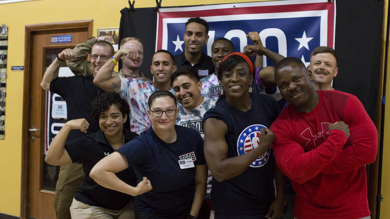 Ruthie Bolton and Kevin Martin flex with service members.