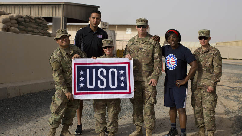 Ruthie Bolton and Kevin Martin smile with service members.
