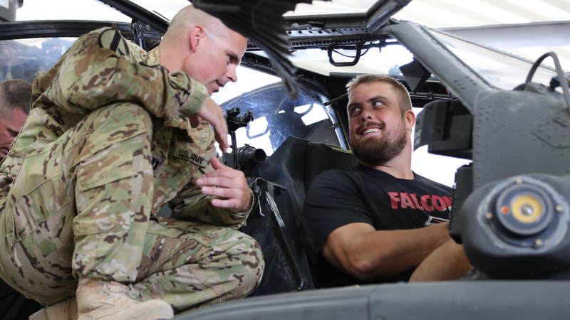 Atlanta Falcons offensive lineman Ben Garland gets a close look at a AH-64 Apache helicopter.