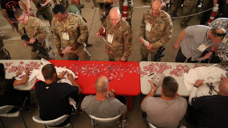 Falcons players, coaches and cheerleaders sign autographs at a USO-hosted event at Erbil Air Base.