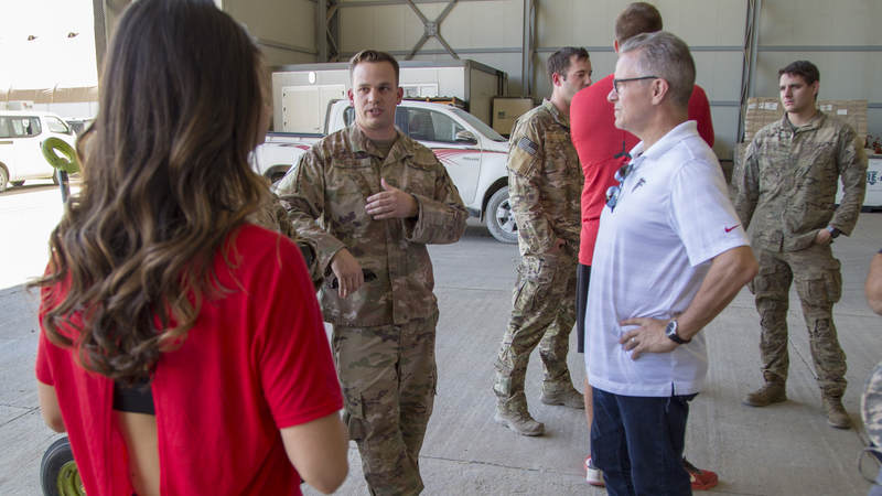 Cheerleader Alexandria Giannini and Falcons CEO Steve Cannon chat with a service member in Erbil, Iraq, during a USO Tour.