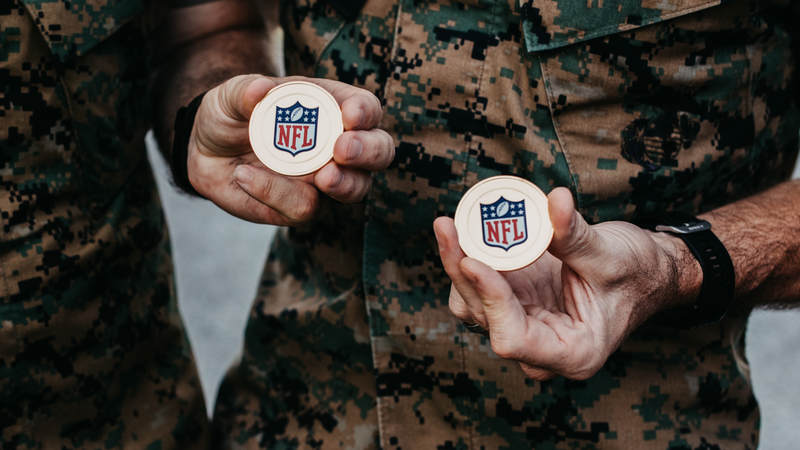 Marines show off some NFL challenge coins during the USO-NFL Legends tour to Okinawa, Japan, on July 25-26. USO photos by Amber Craig