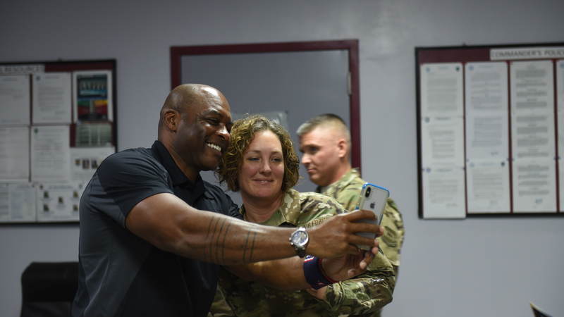 Reggie Sanders takes a photo with a fan while on a USO Tour with Kansas City Royals greats in Kuwait. USO Photo by Neal Preston.