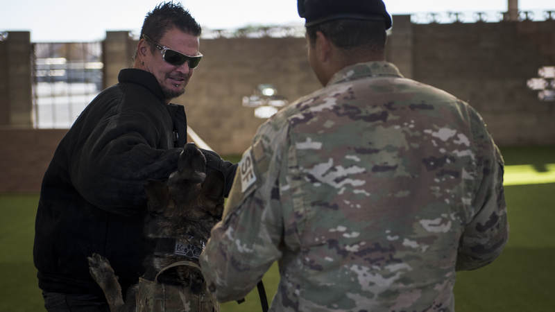 Dan Donegan, guitarist for the band Disturbed, receives a bite from a military working dog during a demonstration at Nellis Air Force Base, Nevada, October 24.