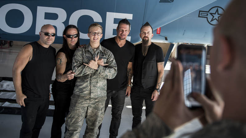 Members of the band Disturbed take a photo with an Airman during a tour of Nellis Air Force Base, Nevada, October 24.