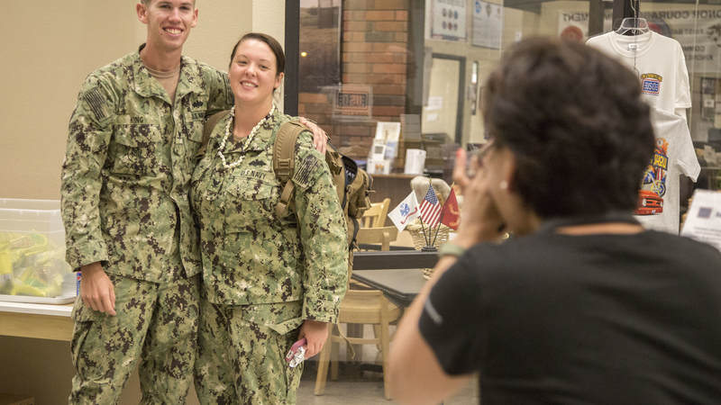 A Navy Seabee couple has their picture taken by USO volunteer Mariza Gatdula on Feb. 8 during a short layover at USO Ontario.