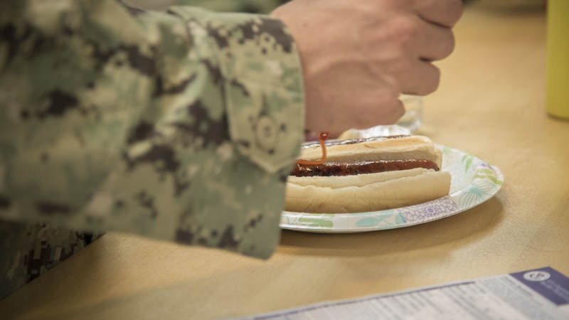 Navy Seabee fixes a freshly grilled hot dog Feb. 8 during a short, late-night layover at USO Ontario.
