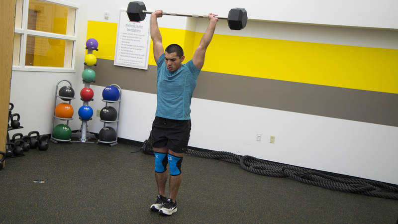 A service member lifts weights at the USO Alaska Wellness Center.