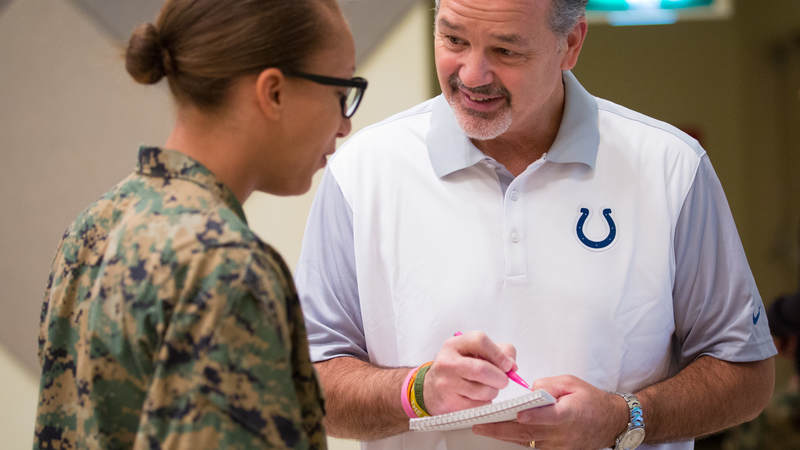 Indianapolis Colts head coach Chuck Pagano signs an autograph for a service member during a USO tour stop at Camp Foster in Okinawa, Japan, on Feb. 19.